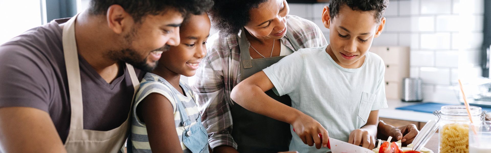 A family is preparing food together in a kitchen.
