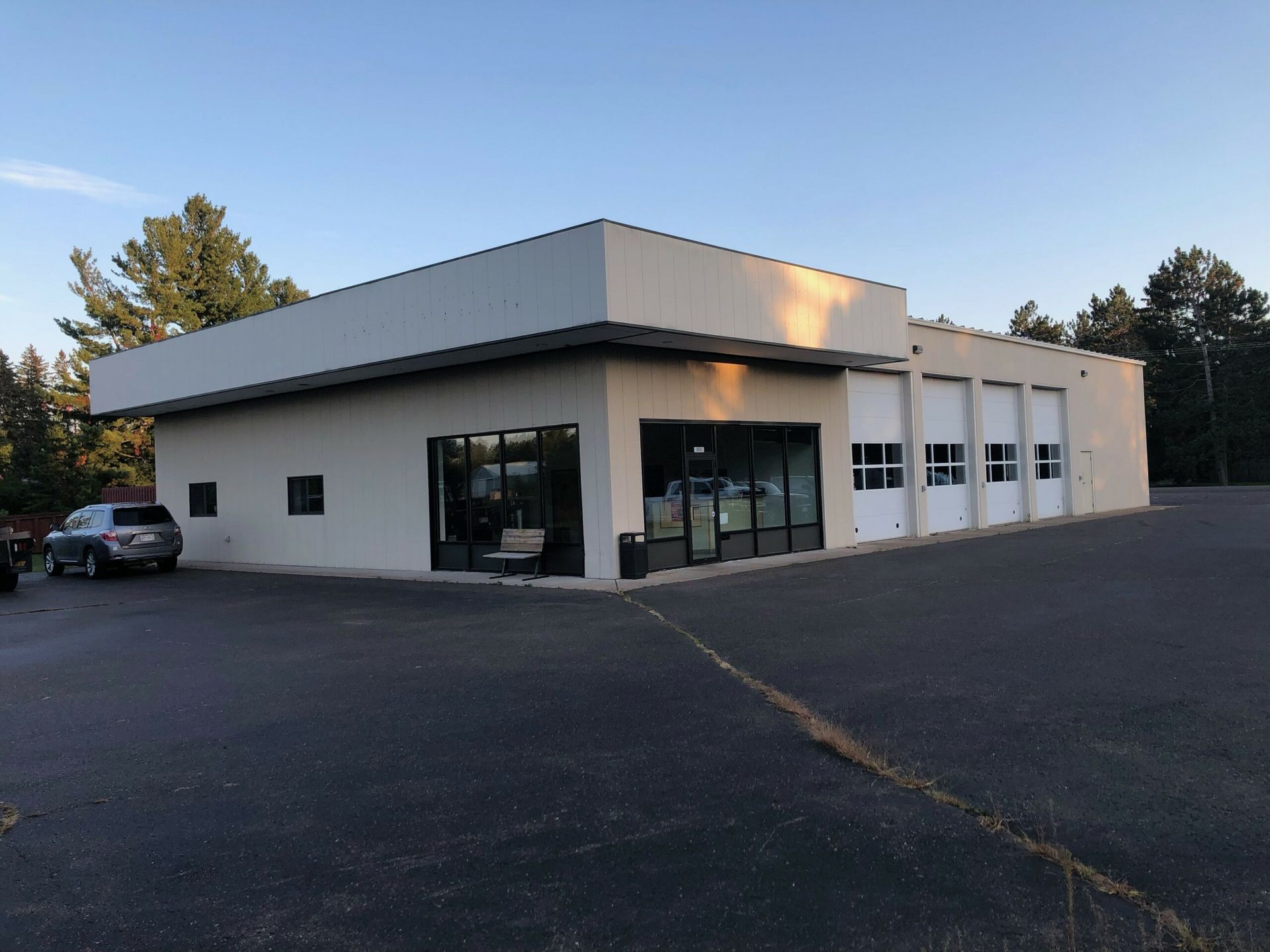 A white building with a lot of windows and a car parked in front of it.