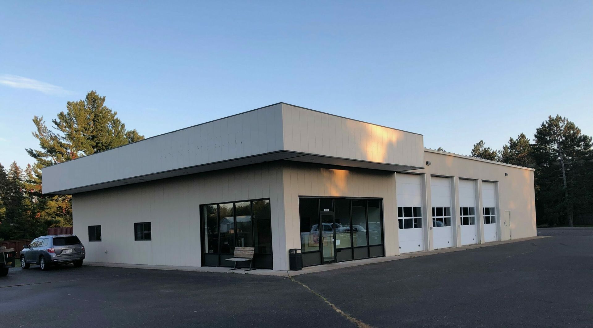 A white building with a car parked in front of it