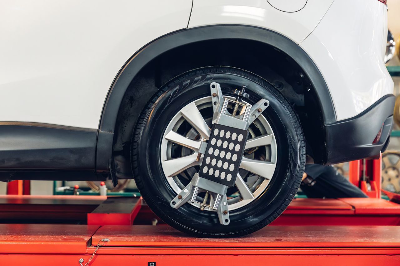A car is being aligned with a machine in a garage.