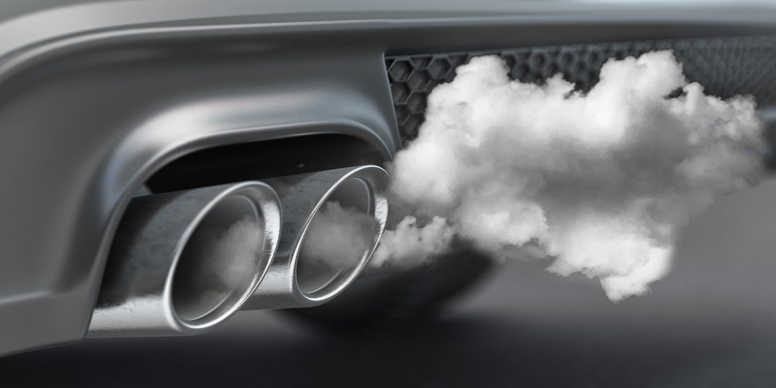 Smoke is coming out of the exhaust pipe of a car.