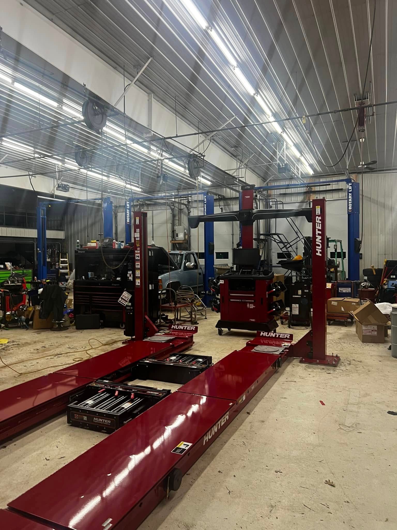 A large garage with a lot of red lifts in it