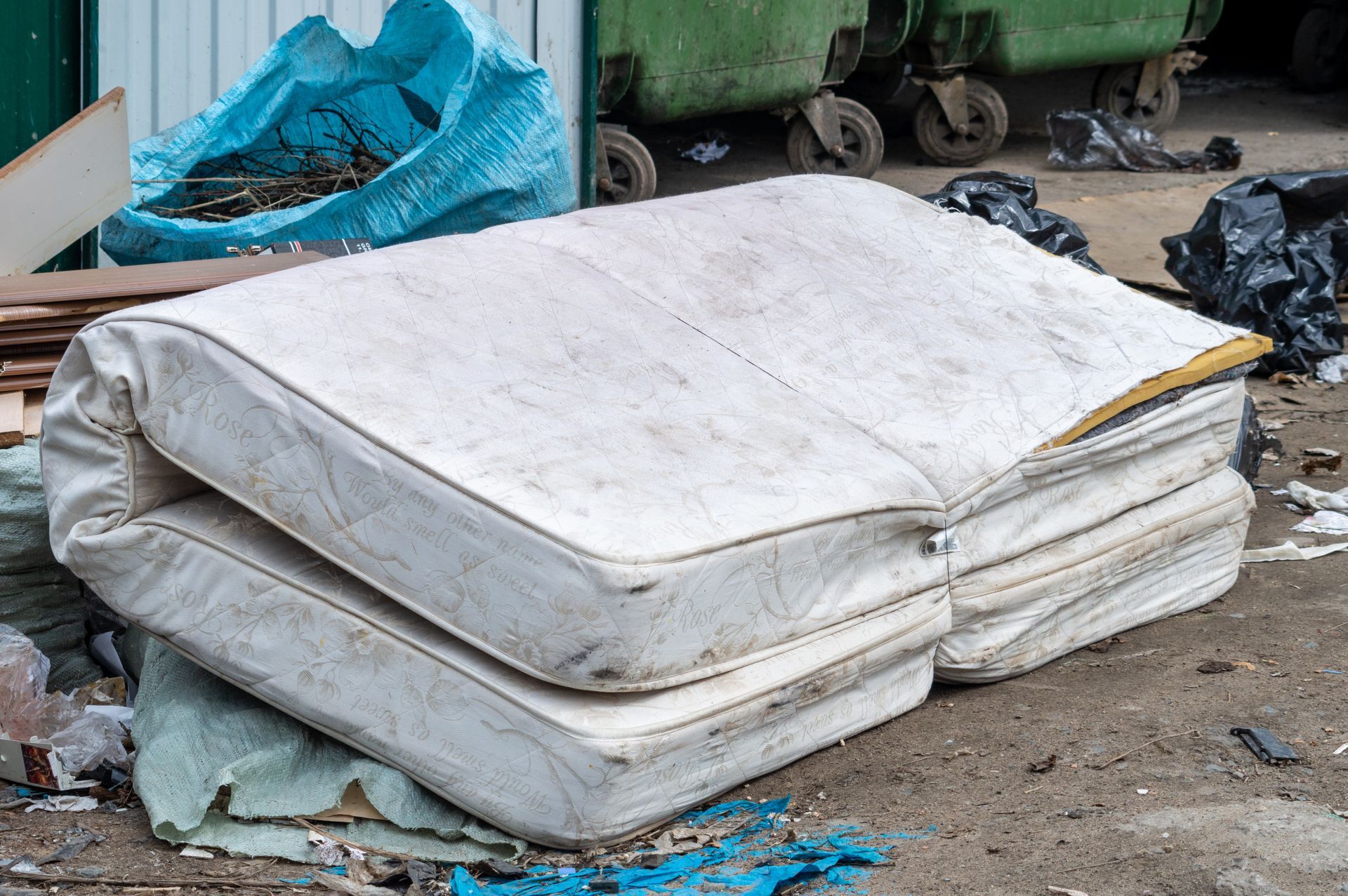 two mattresses are stacked on top of each other on the ground .