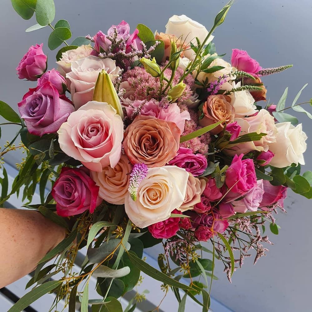 A Person Is Holding A Bouquet Of Flowers In Their Hand — Clover Country Flowers and Gifts In Highfields, QLD