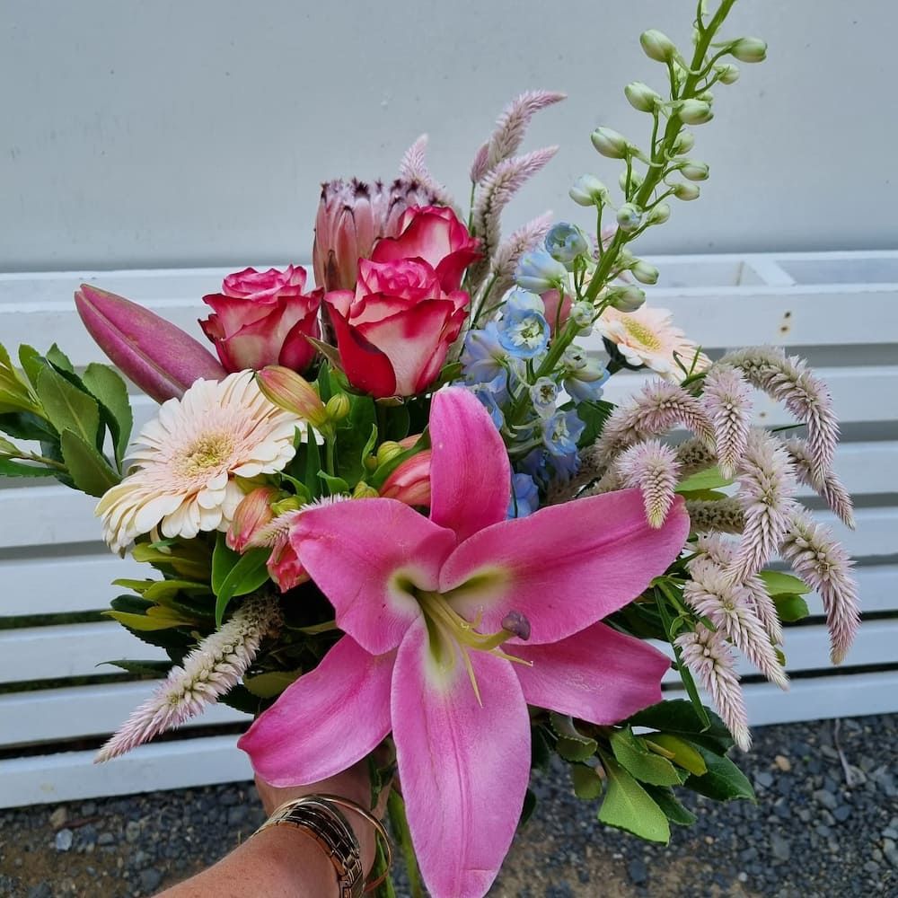 A Person Is Holding A Bouquet Of Pink Flowers In A Vase — Clover Country Flowers and Gifts In Toowoomba, QLD