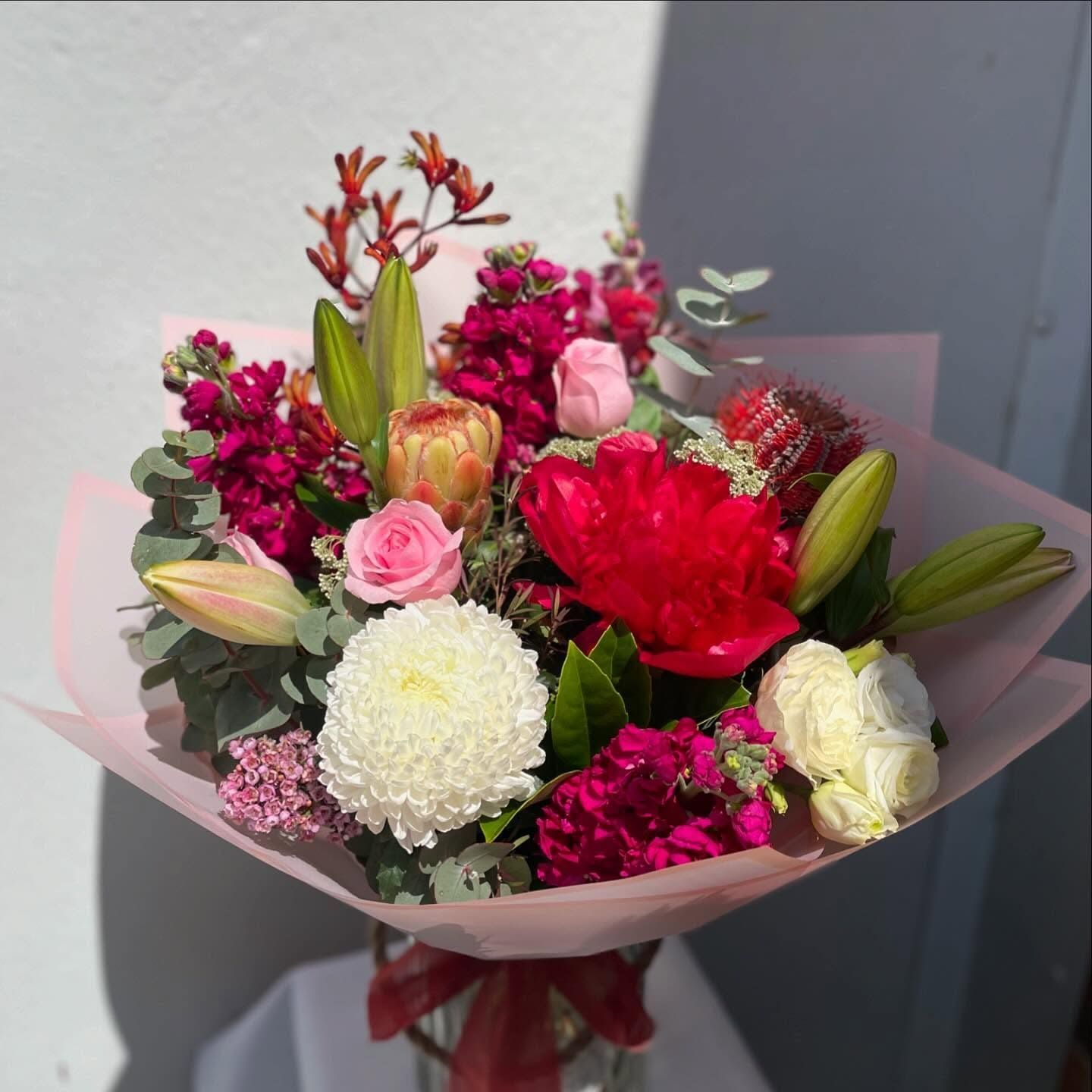 A Bouquet Of Flowers Wrapped In Pink Paper Is Sitting On A Table — Clover Country Flowers and Gifts In Pittsworth, QLD