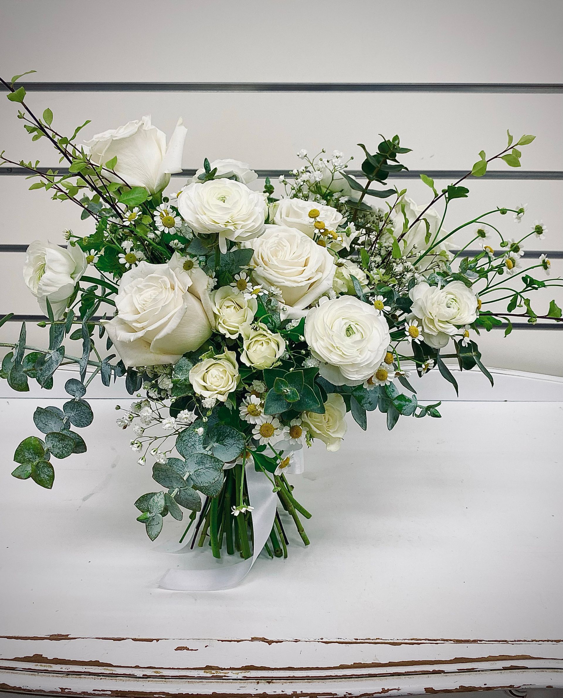 A Bouquet Of Flowers Wrapped In Red Paper Is Sitting On A Table — Clover Country Flowers and Gifts In Pittsworth, QLD
