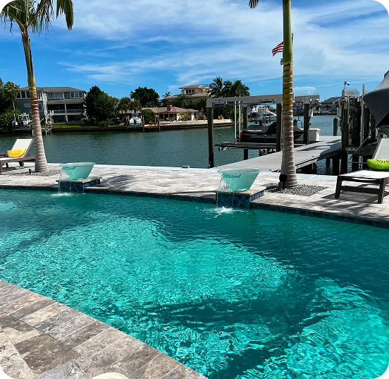 Pool steps with blue and iridescent mosaic tiles submerged in clear water.