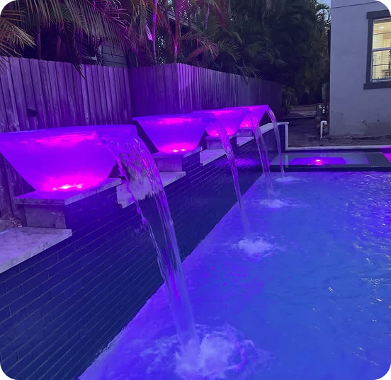 Pool steps with blue and iridescent mosaic tiles submerged in clear water.