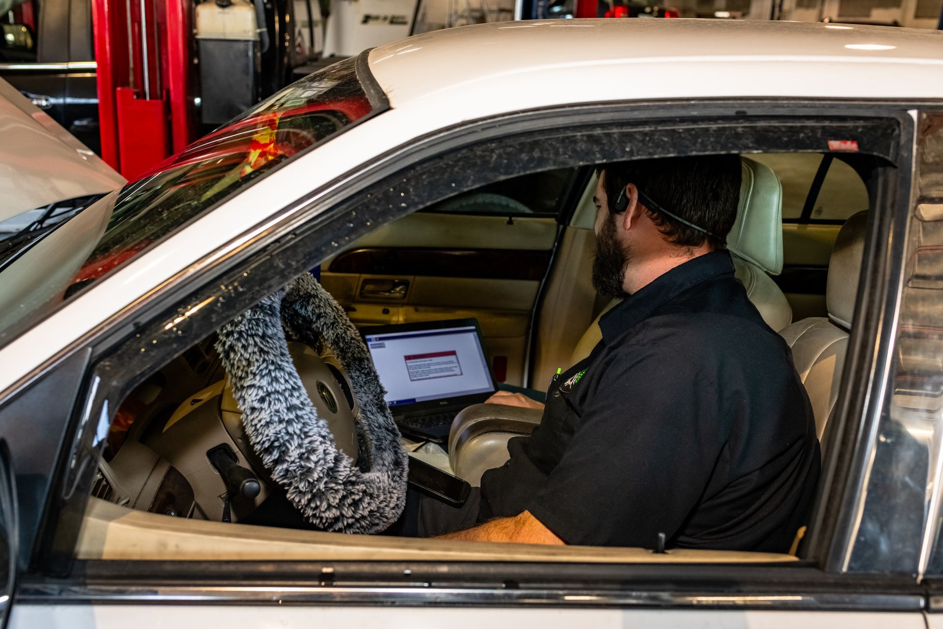 A man is standing in a garage next to a truck.