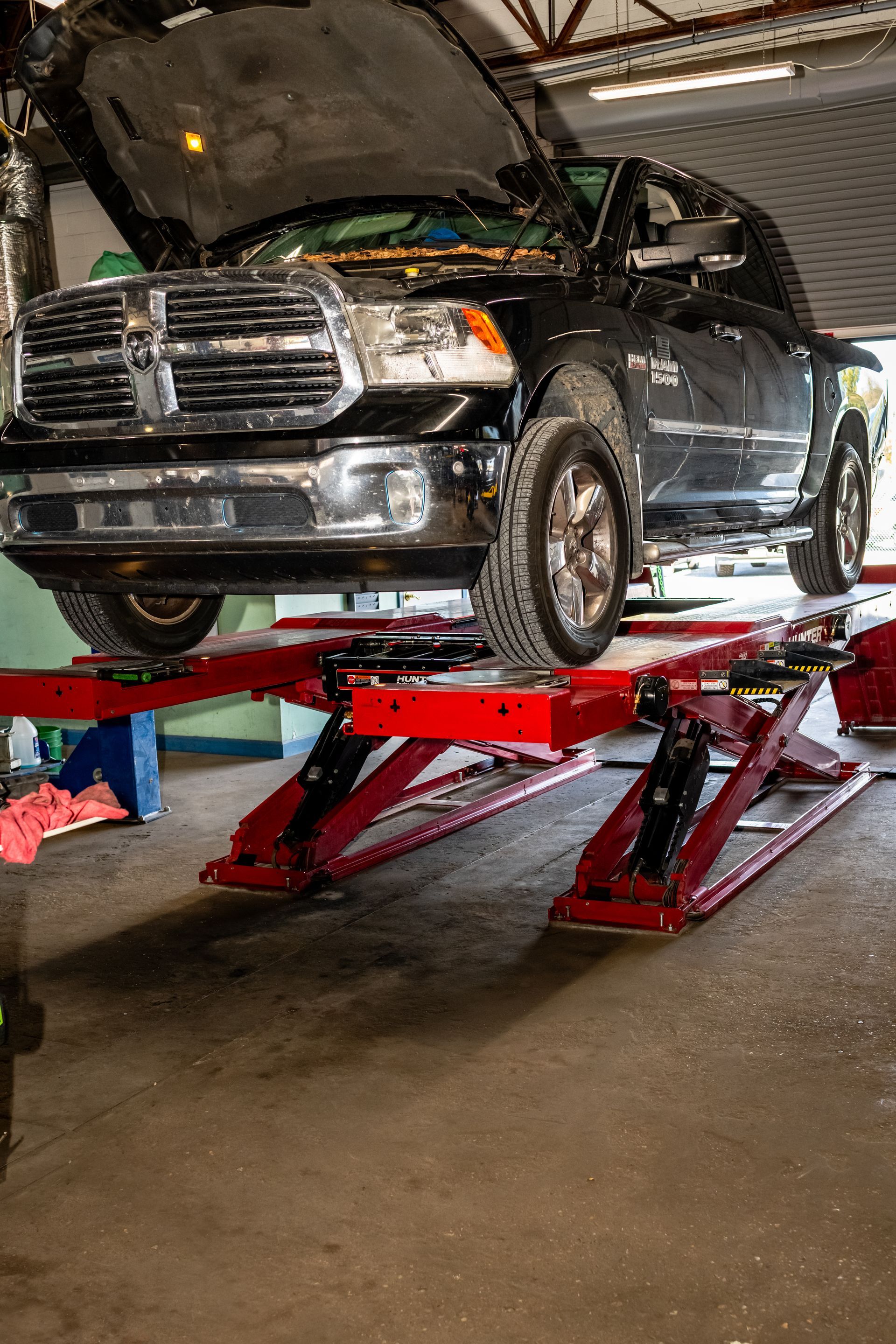 Two men are working on a car engine in a garage.