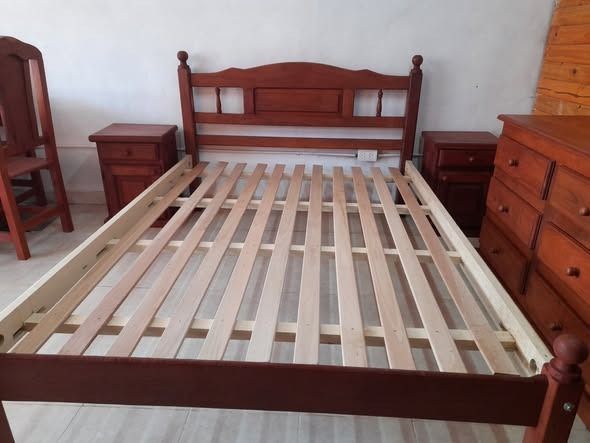 Estructura de cama de madera con cabecero, dos mesitas de noche y una cómoda.