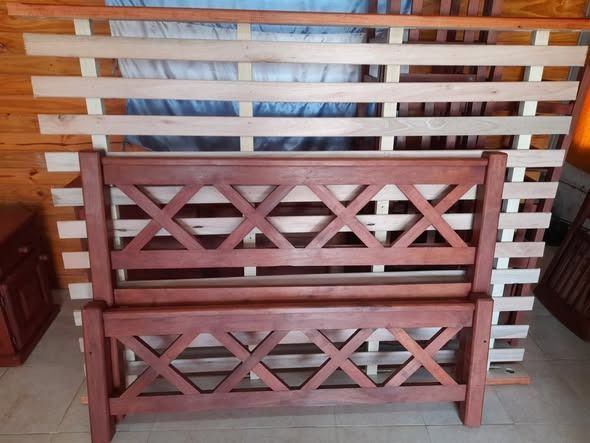 Estructura de cama de madera de color marrón rojizo con diseño en