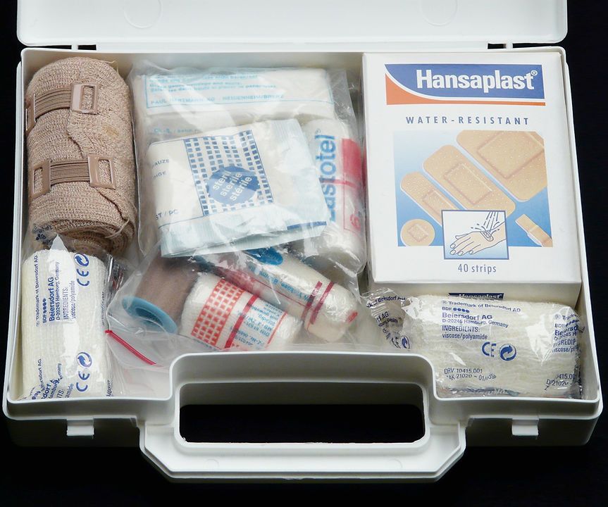 A first aid kit with a box of hansaplast bandages