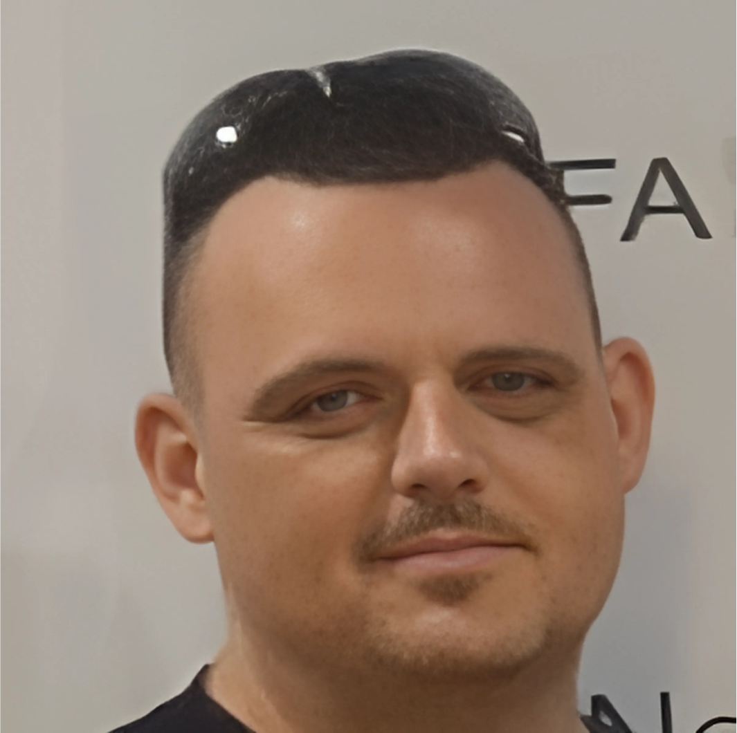 A man wearing sunglasses stands in front of a sign that says fa