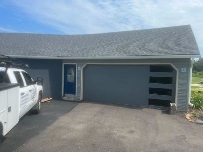 A white truck is parked in front of a garage door.