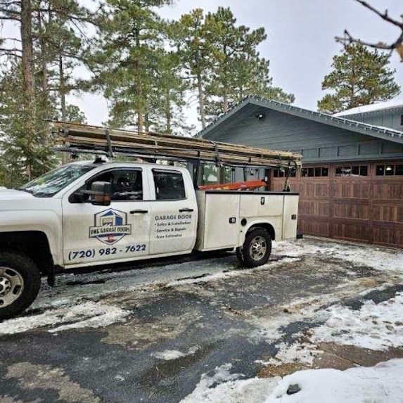 A white truck is parked in front of a house in the snow.