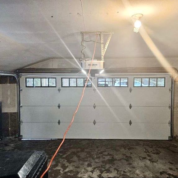 A garage door with a lift and a light hanging from the ceiling.