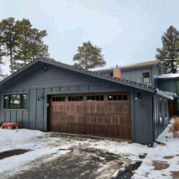 A house with a garage door is covered in snow.