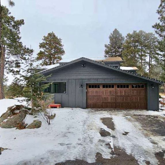 A house with a garage and a driveway covered in snow.