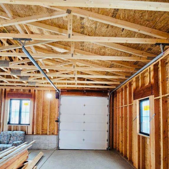A garage under construction with a white garage door.
