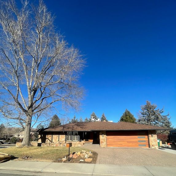A house with a tree in front of it on a sunny day