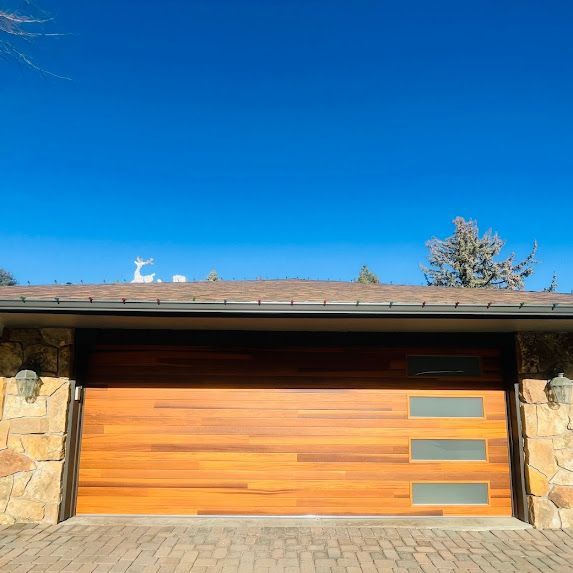 A wooden garage door with a deer on the roof.