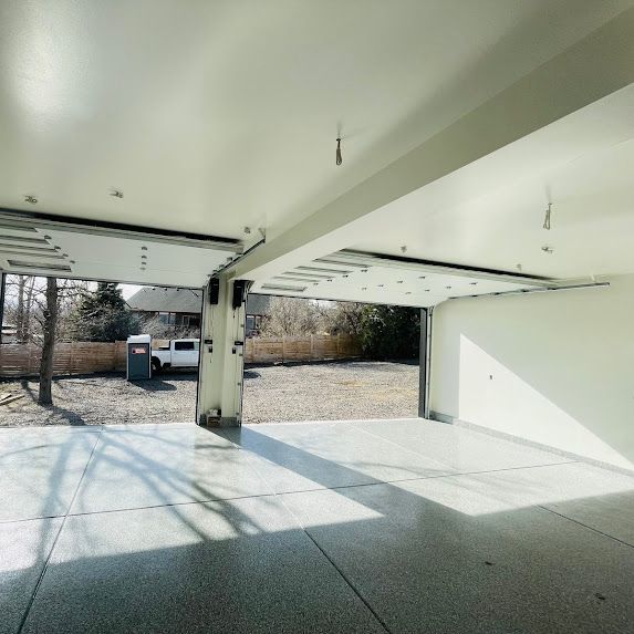 An empty white garage with the door open