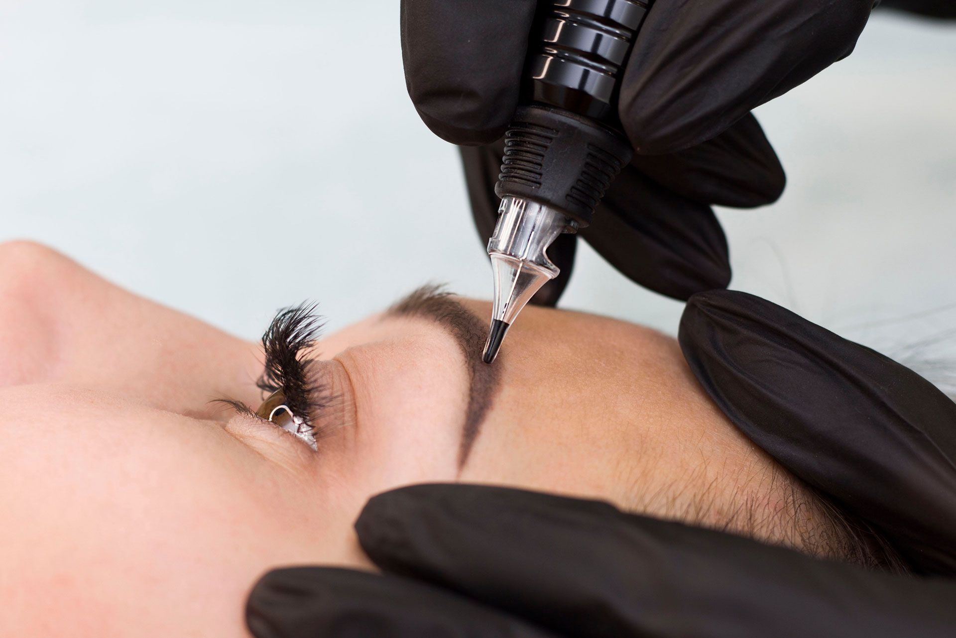 A woman is getting a microblading in a salon