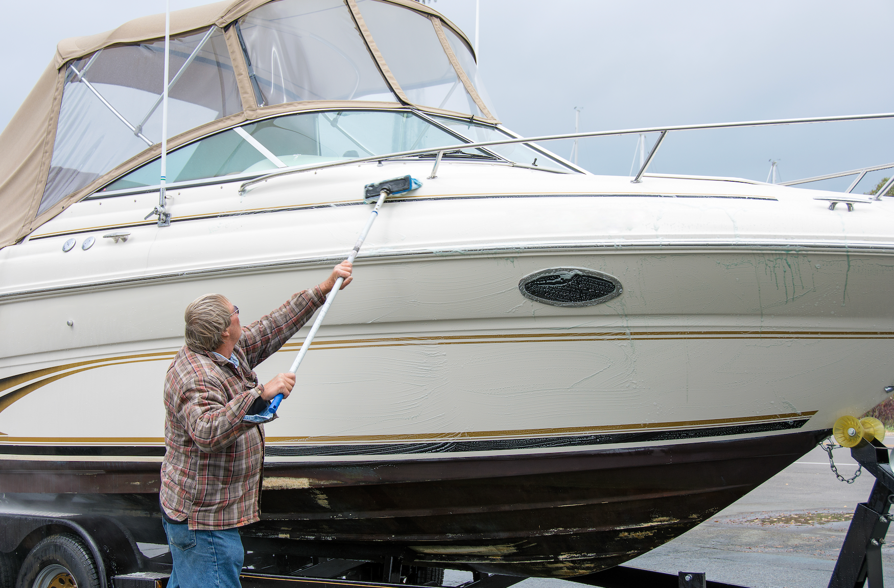 A man is cleaning a boat with a broom