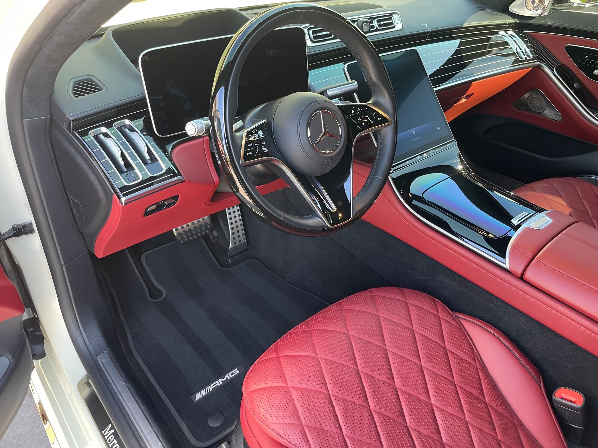 Red-interior Mercedes-Benz car interior. Steering wheel, dashboard, and seats.