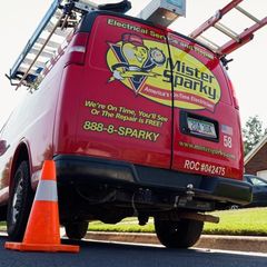 a red mister sparky van is parked on the side of the road