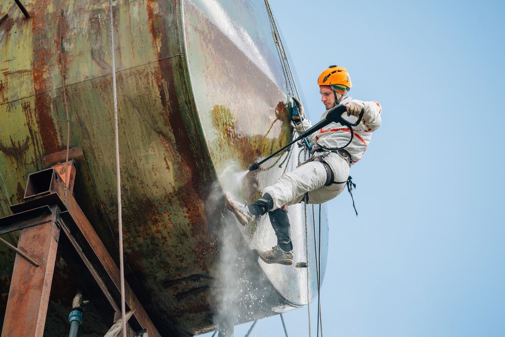 Pressure Washer Cleaning Outside a tank — Ultra-High Pressure Water Blasting in the Northern Territory
