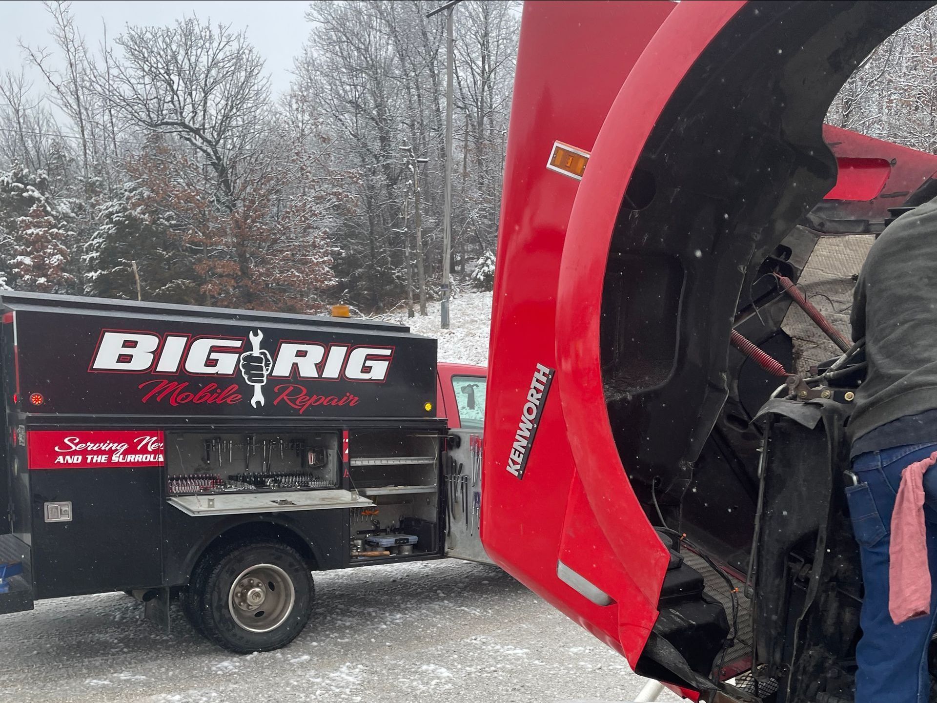 a big rig van is parked in the woods next to a bulldozer .