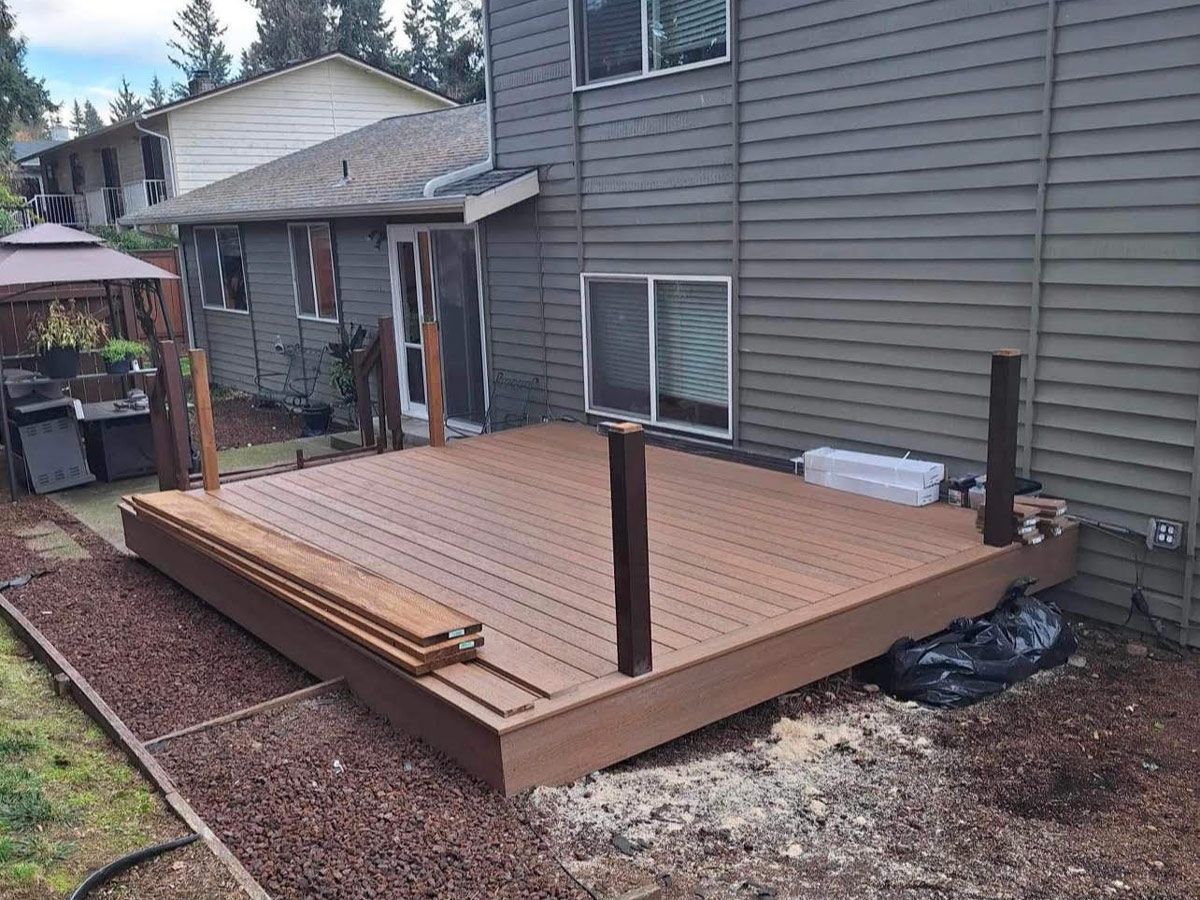 A wooden deck is being built in the backyard of a house by tonys roofcare in edgewood wa.