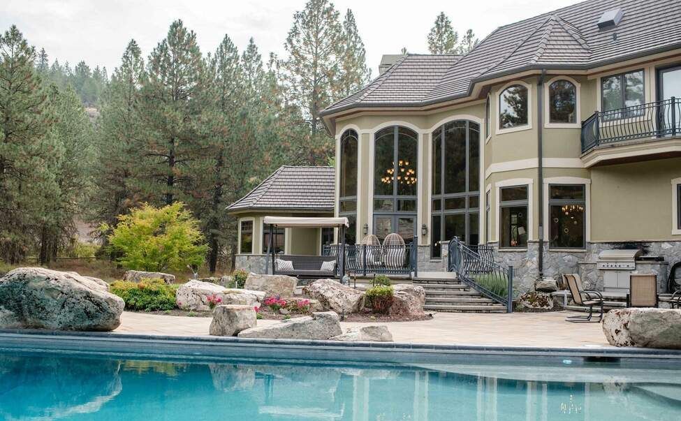 A large house with a swimming pool in front of it