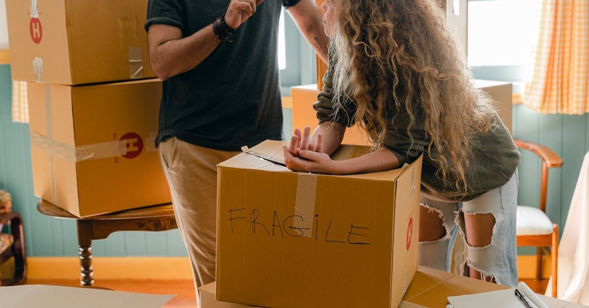 A man and a woman are standing next to a cardboard box.