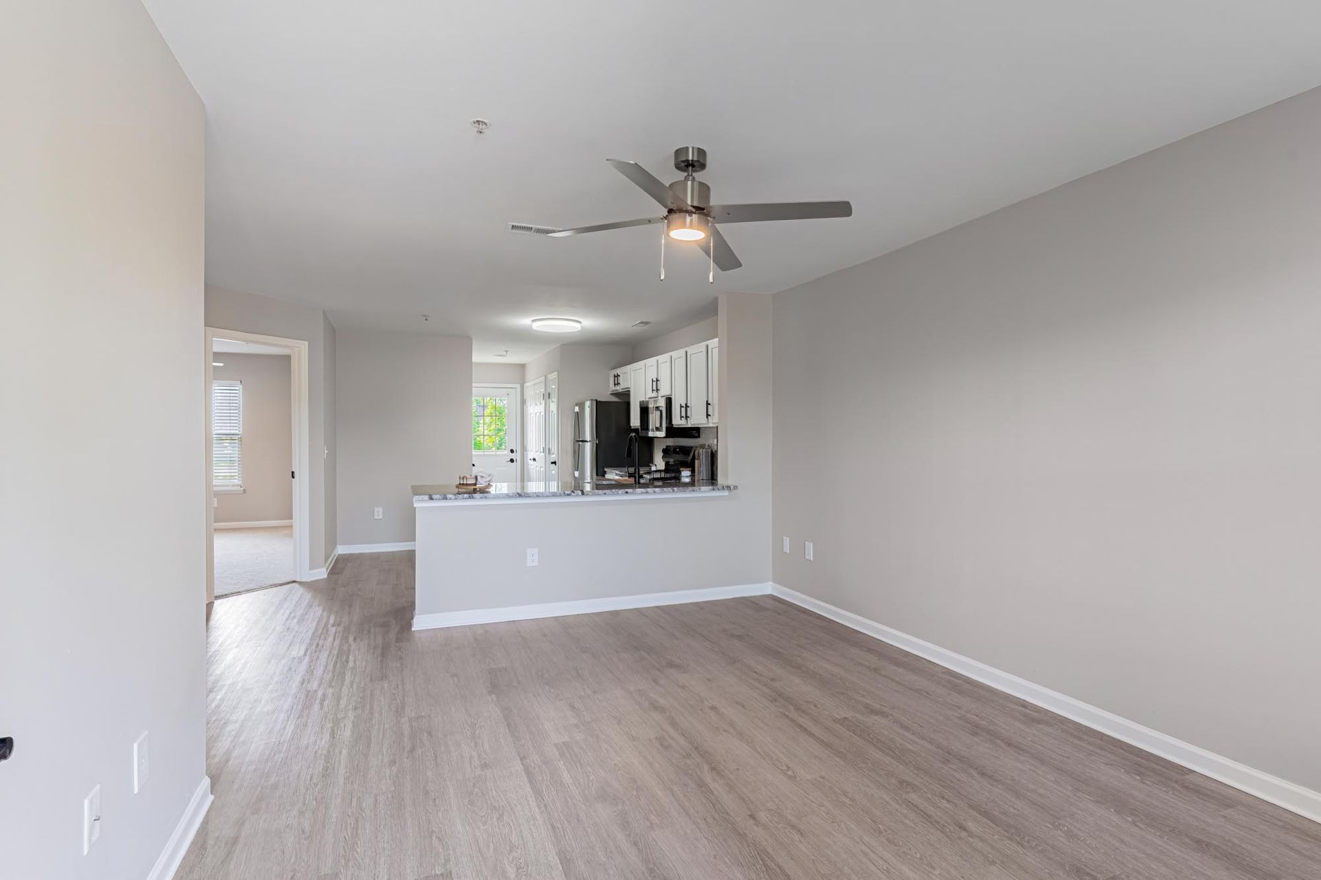 Pool area with turquoise water, lounge chairs, and a two-story apartment building.