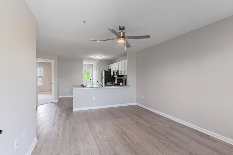 Pool area with turquoise water, lounge chairs, and a two-story apartment building.
