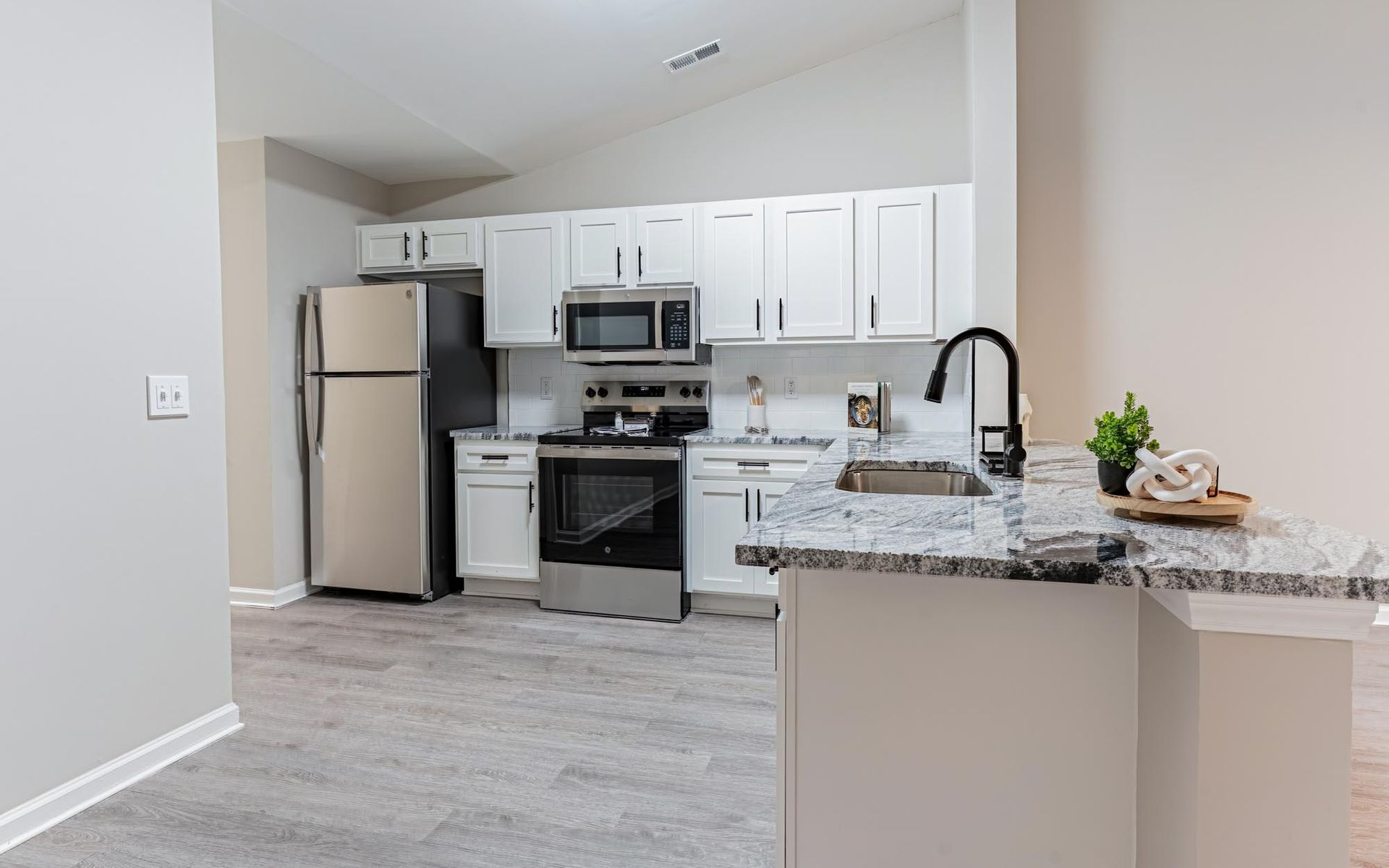 Pool area with turquoise water, lounge chairs, and a two-story apartment building.