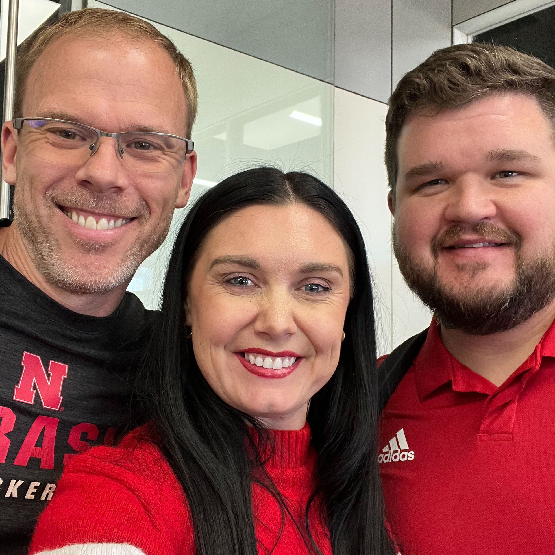 Two men and a woman are posing for a picture together