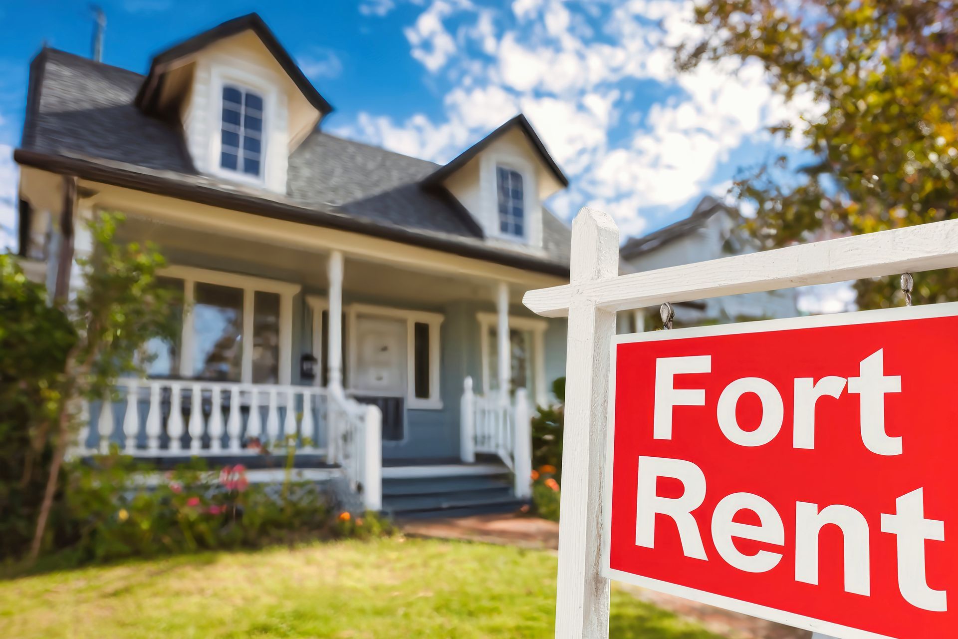 A house with a for rent sign in front of it