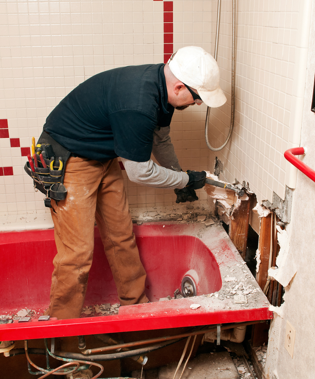 A man is working on a bathtub in a bathroom