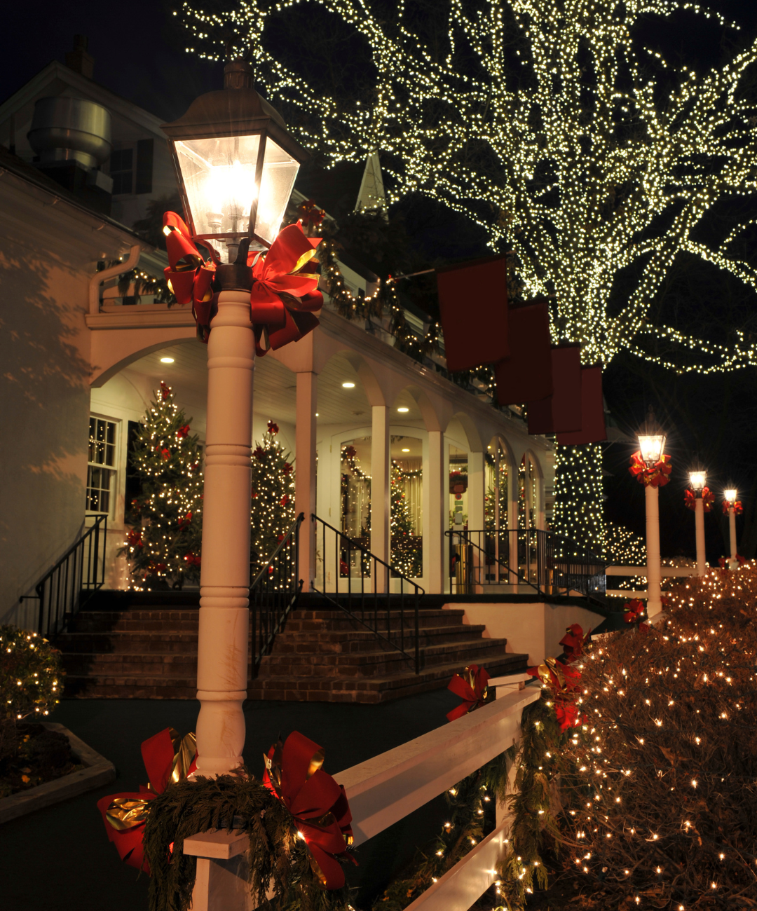 A street light is lit up in front of a house decorated for christmas