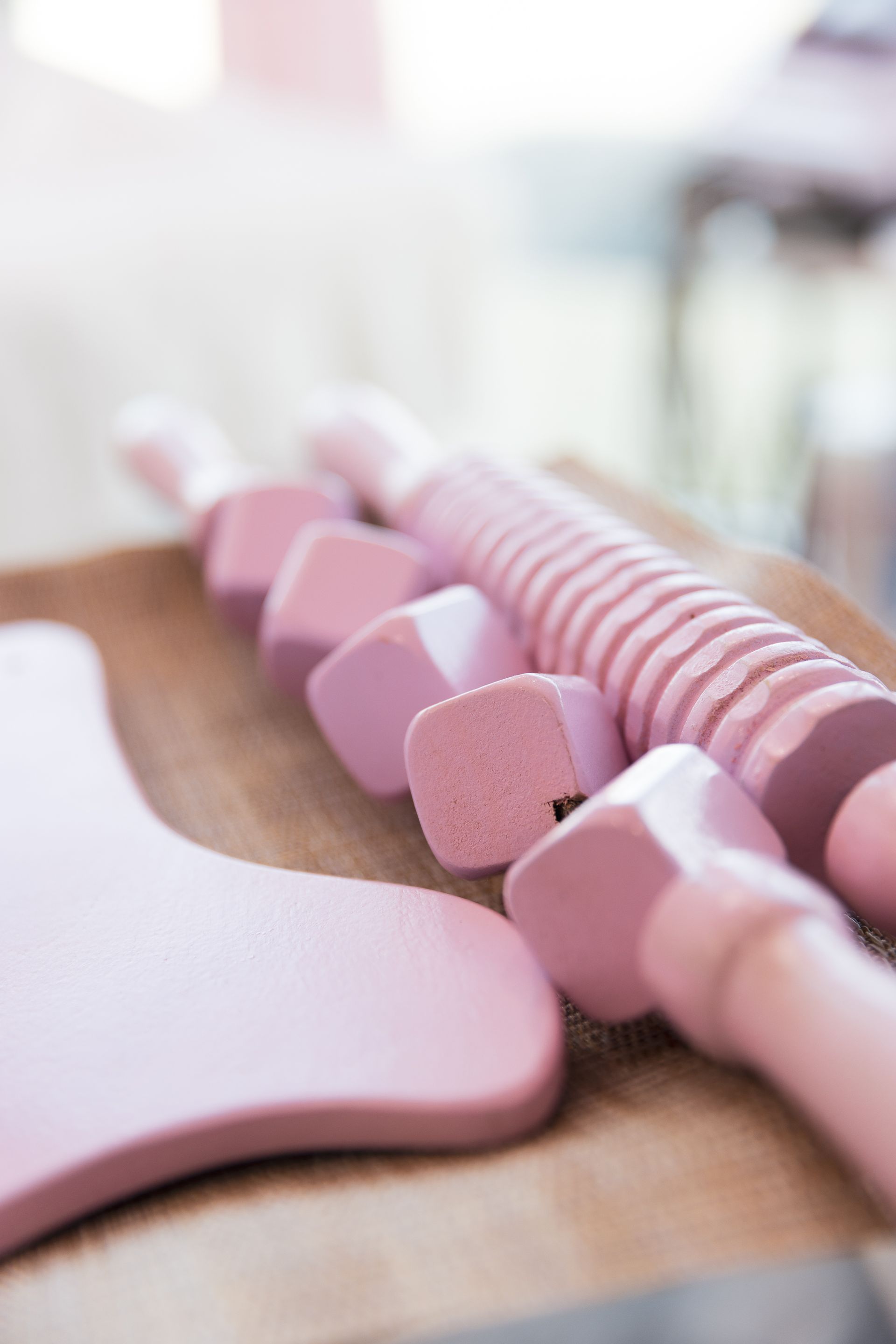 A bunch of pink objects are sitting on a wooden table.