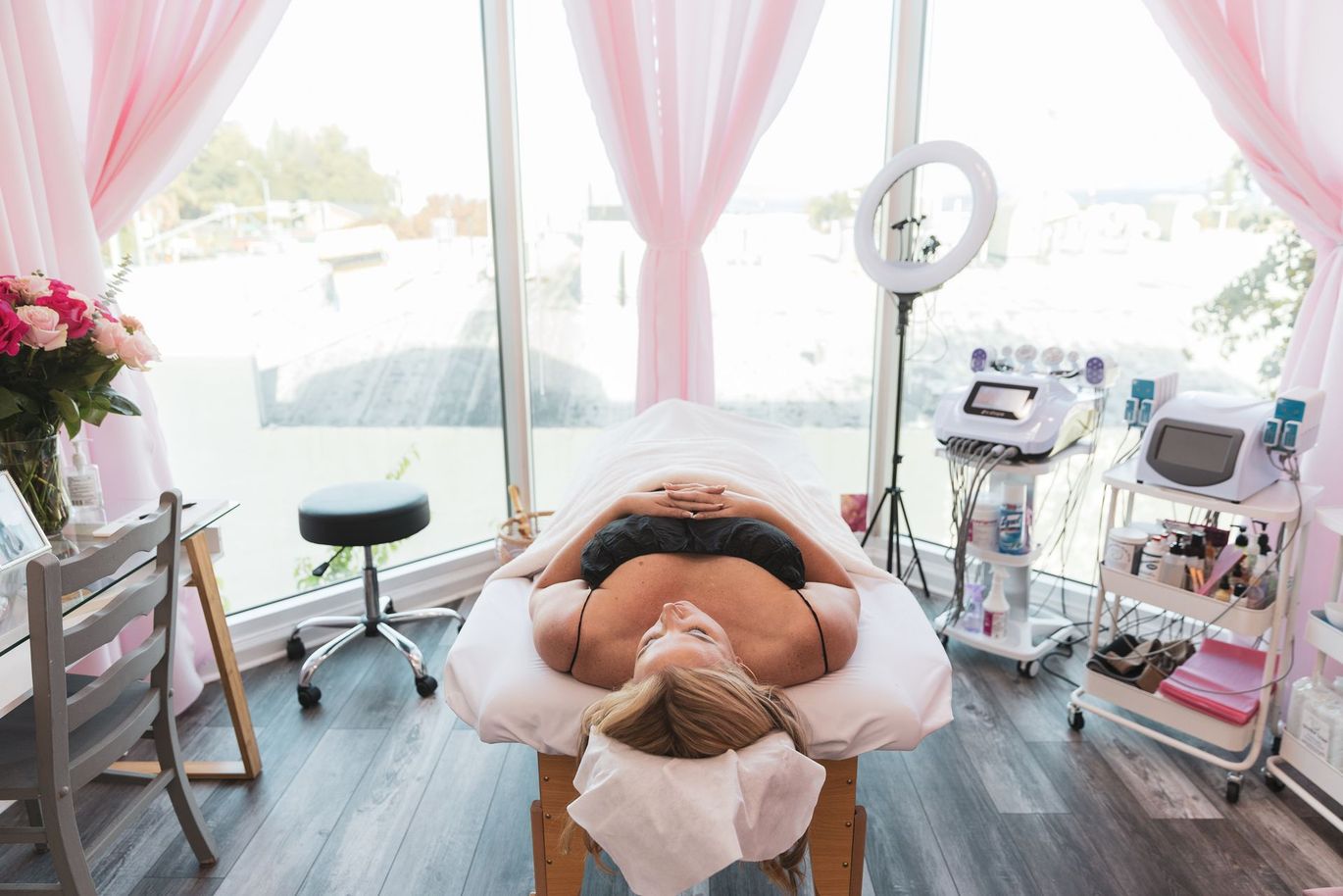 A woman is laying on a massage table in a beauty salon.