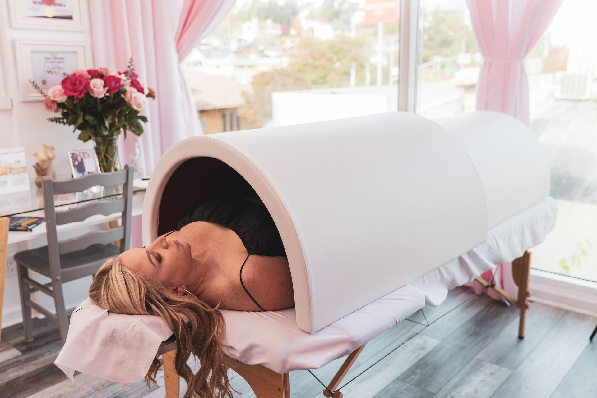 A woman is laying on a table in a sauna.