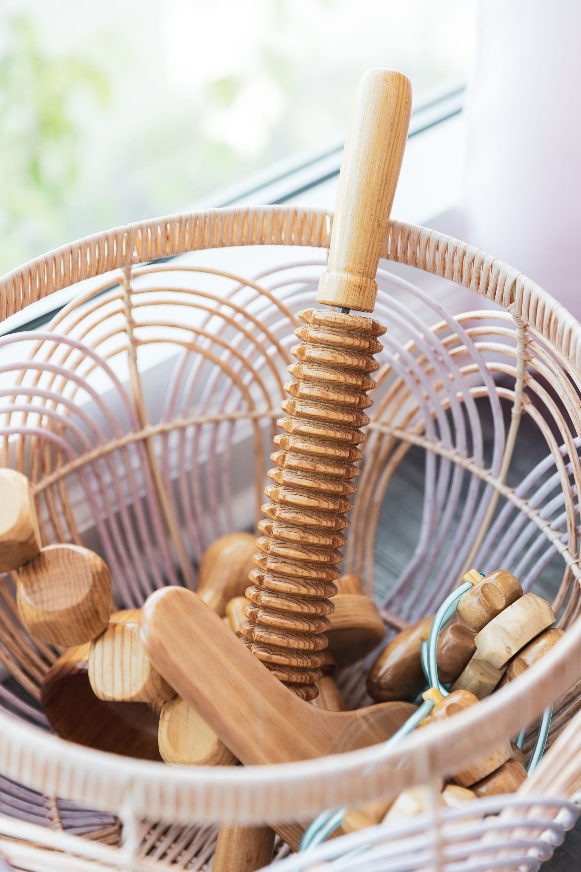 A basket filled with wooden toys is sitting on a table.