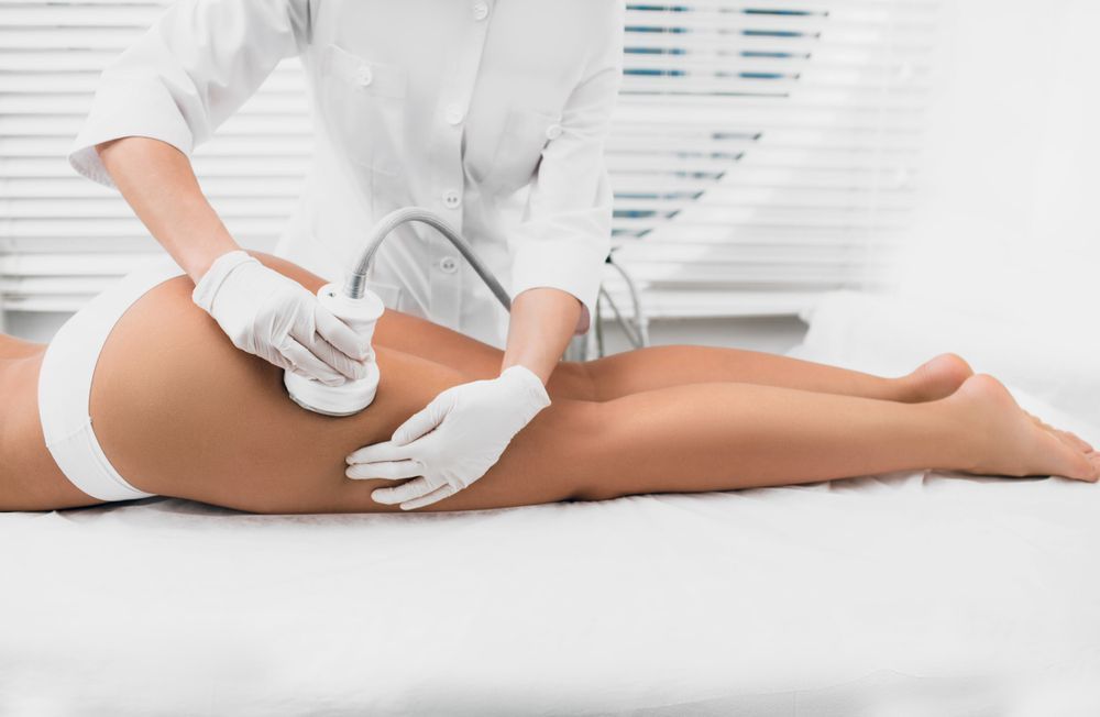 A woman is getting an ultrasound treatment on her leg.