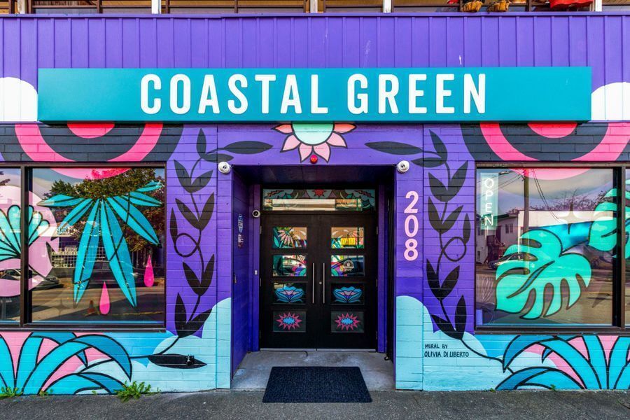The front of a building with a sign that says coastal green.